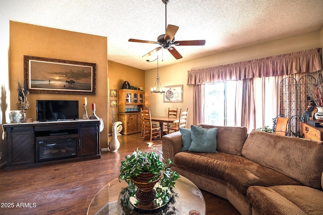 living area with ceiling fan, a textured ceiling, wood finished floors, and lofted ceiling