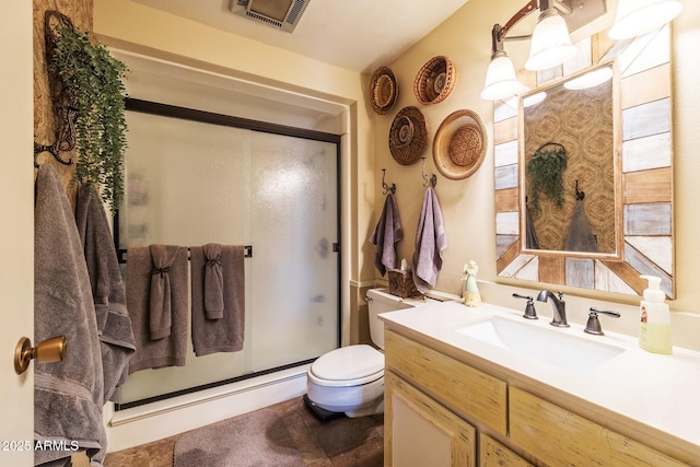 bathroom featuring visible vents, a shower stall, toilet, and vanity