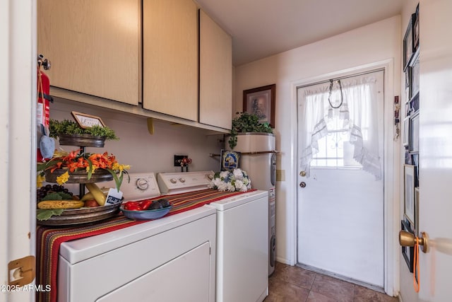 laundry room with cabinet space, water heater, light tile patterned floors, and washer and dryer