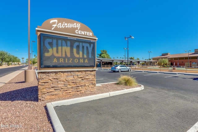 community / neighborhood sign featuring uncovered parking