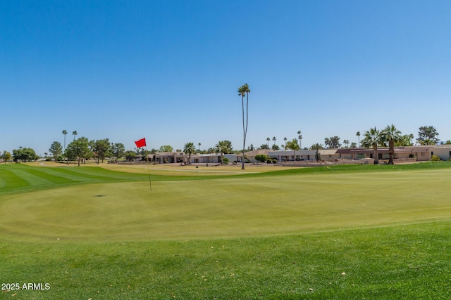 view of home's community with view of golf course and a lawn