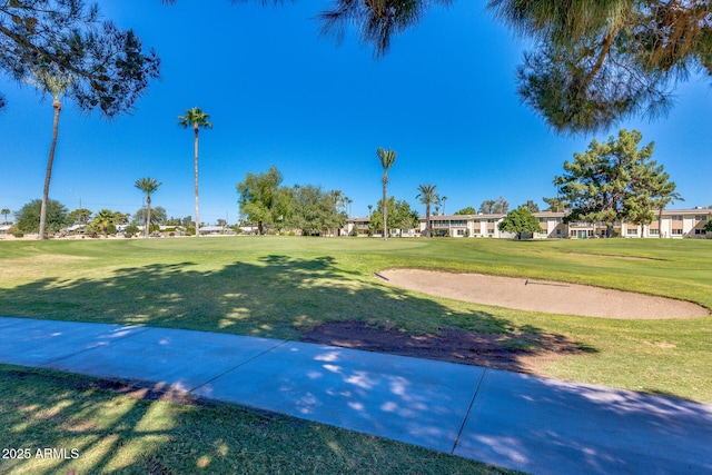 surrounding community featuring a lawn and golf course view