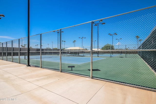 view of tennis court featuring fence