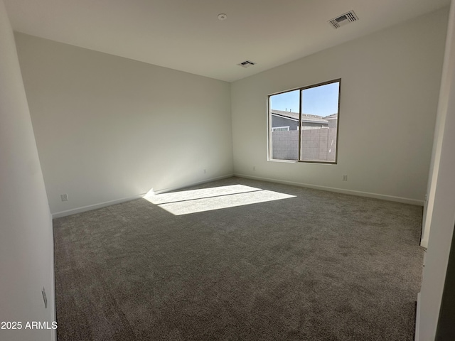 carpeted spare room featuring baseboards and visible vents