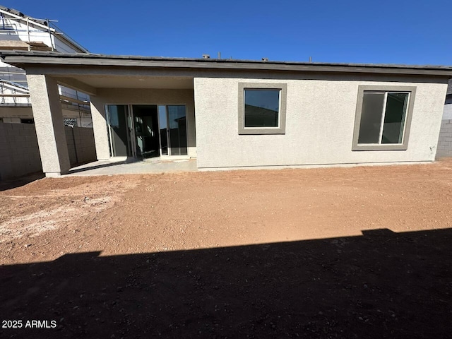 back of property featuring stucco siding