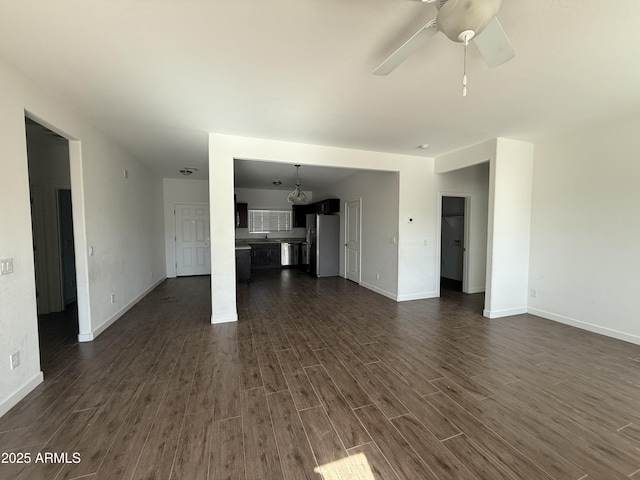 unfurnished living room featuring dark hardwood / wood-style flooring and ceiling fan