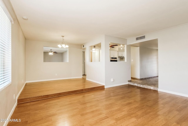4062 W Eva St, Phoenix, AZ 85051 - empty room with ceiling fan, a chandelier, light wood-style flooring, and baseboards