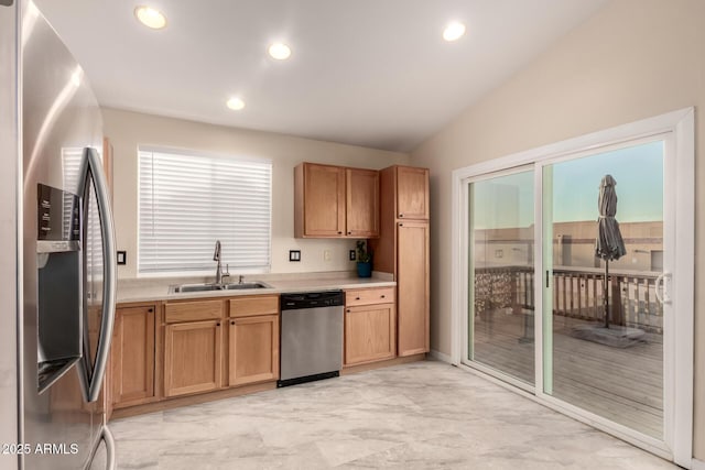 kitchen featuring lofted ceiling, marble finish floor, stainless steel appliances, light countertops, and a sink