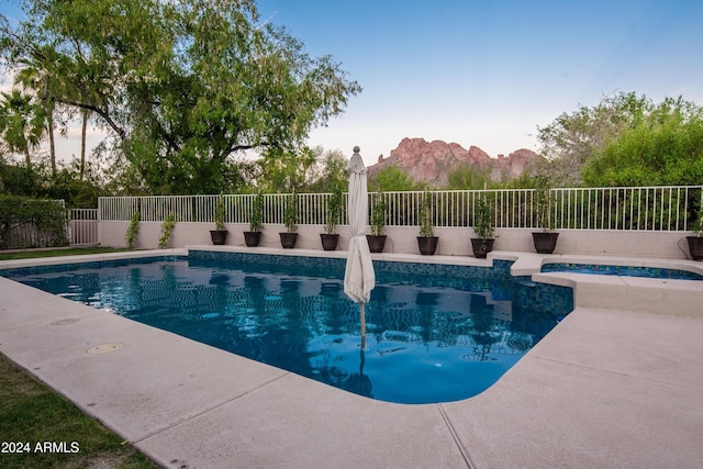 view of pool featuring a mountain view, a patio, and an in ground hot tub