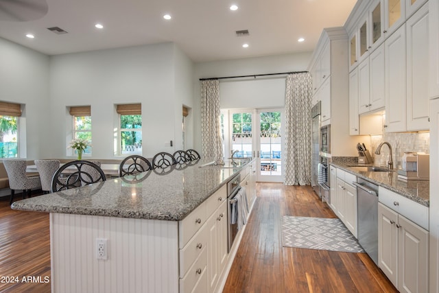 kitchen featuring dishwasher, a wealth of natural light, dark hardwood / wood-style floors, and a spacious island