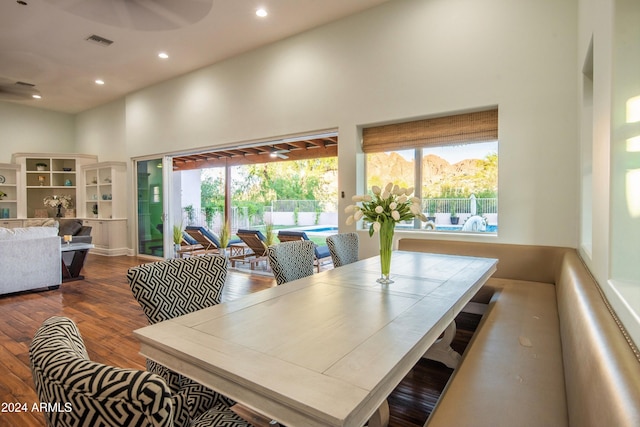 dining room with hardwood / wood-style floors and a towering ceiling