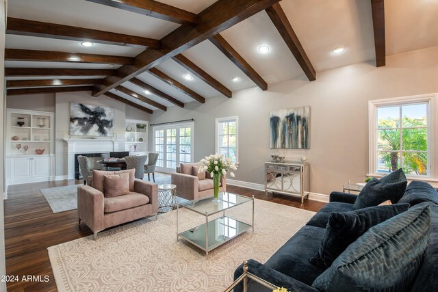 living room featuring built in shelves, wood-type flooring, and vaulted ceiling with beams