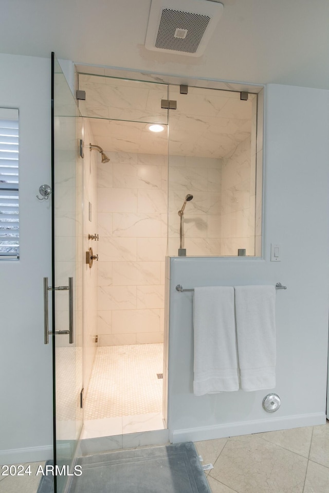 bathroom featuring an enclosed shower and tile patterned flooring