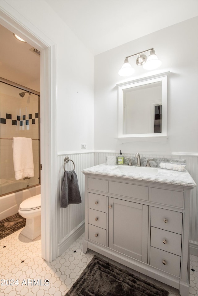 full bathroom with toilet, vanity, and tiled shower / bath