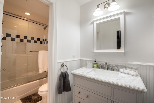 full bathroom with toilet, vanity, and shower / bath combination with glass door