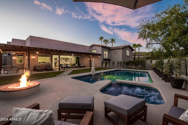 pool at dusk with a fire pit and a patio area