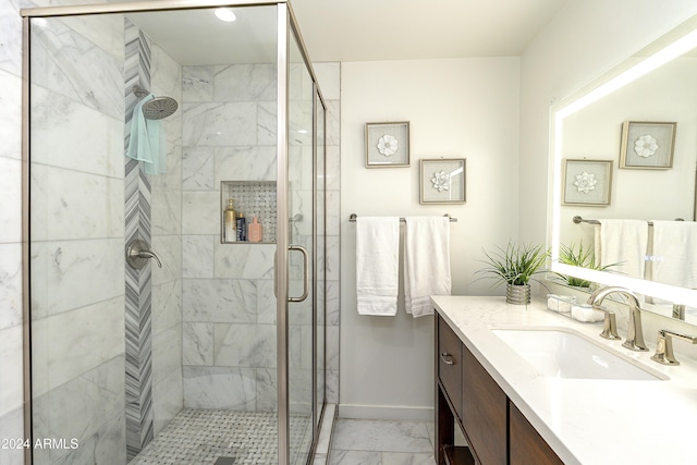 bathroom with a shower with door and vanity