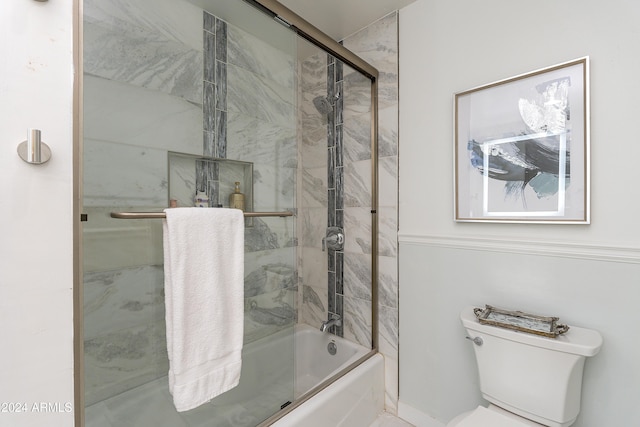 bathroom with toilet and combined bath / shower with glass door