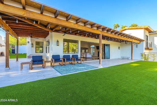 back of property featuring outdoor lounge area, ceiling fan, a yard, and a patio area