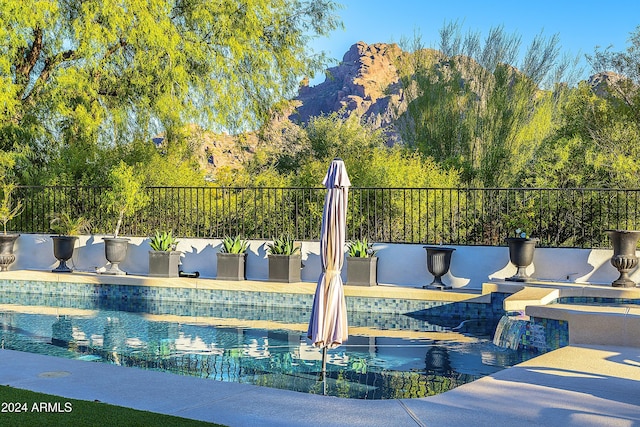 view of swimming pool featuring a patio area and a mountain view