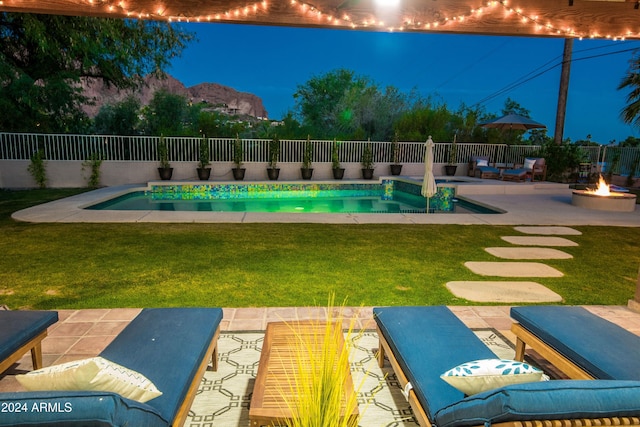 view of swimming pool featuring a fire pit, a lawn, and a patio area