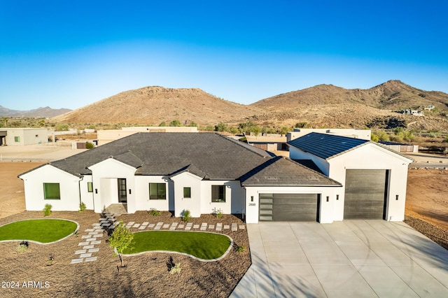 view of front of house featuring a mountain view, a garage, and a front lawn