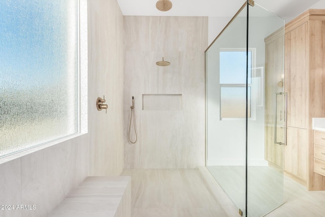 bathroom with a tile shower and vanity