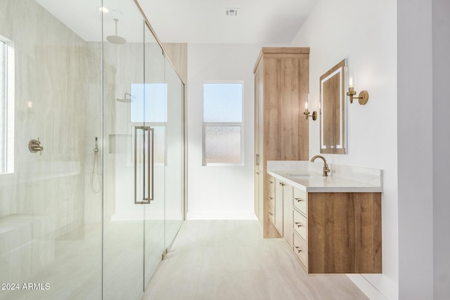 bathroom with vanity, a healthy amount of sunlight, and walk in shower