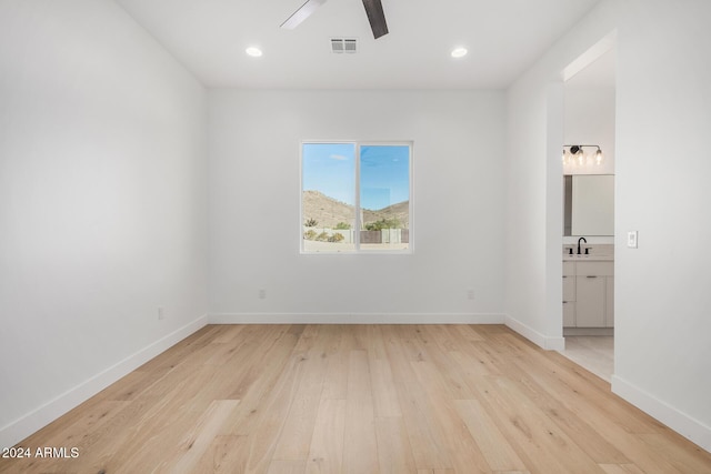 unfurnished room with light hardwood / wood-style flooring, ceiling fan, and sink