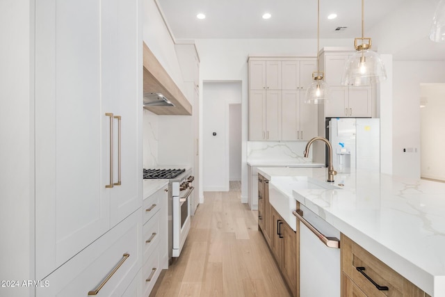 kitchen featuring light stone counters, white appliances, white cabinets, light hardwood / wood-style floors, and hanging light fixtures