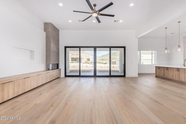 unfurnished living room featuring light hardwood / wood-style floors and ceiling fan