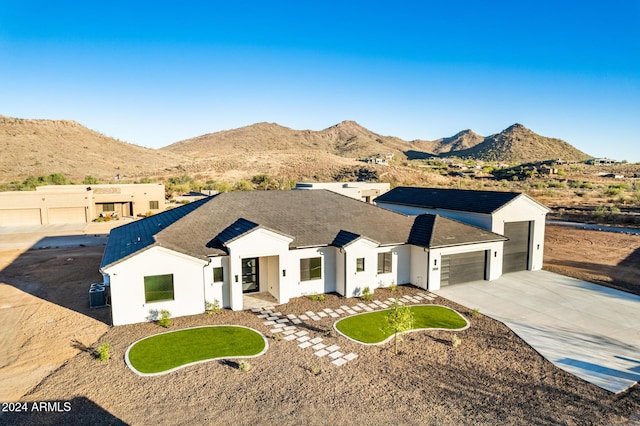 view of front facade featuring central AC, a mountain view, and a garage