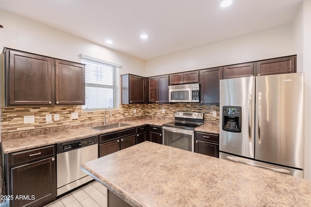 kitchen featuring recessed lighting, backsplash, appliances with stainless steel finishes, a sink, and dark brown cabinetry