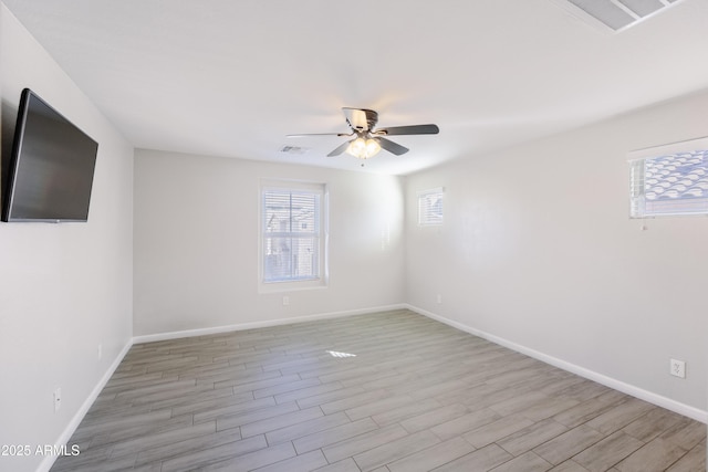 empty room with visible vents, ceiling fan, light wood-style flooring, and baseboards