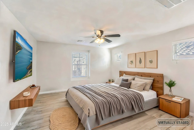 bedroom featuring a ceiling fan, baseboards, visible vents, and light wood finished floors