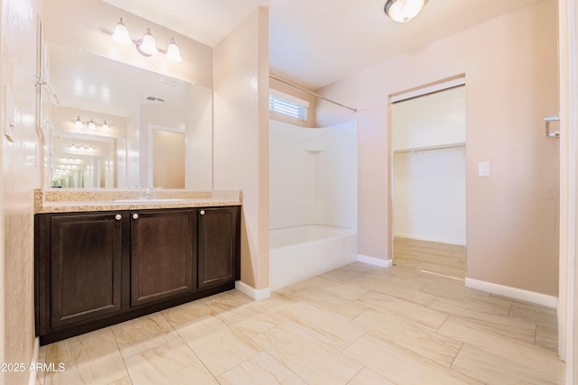 bathroom with bathtub / shower combination, visible vents, vanity, and baseboards