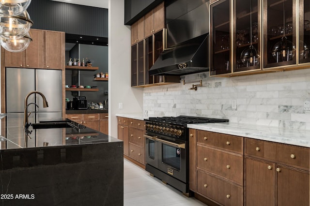 kitchen with sink, stainless steel fridge, dark stone countertops, double oven range, and backsplash