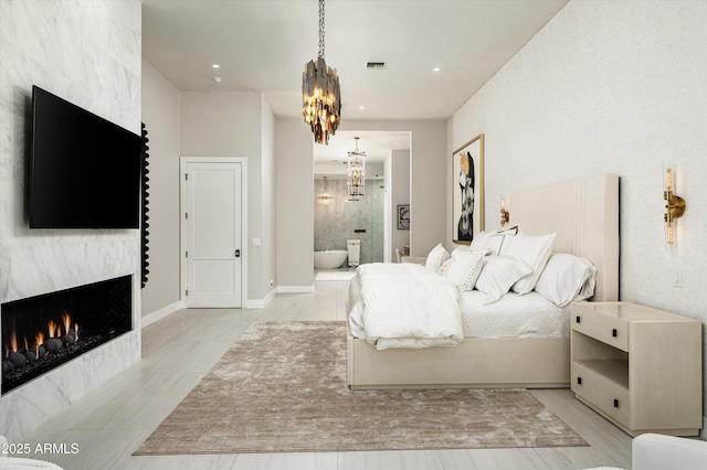 bedroom with ensuite bathroom and a notable chandelier