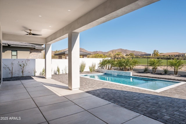 view of pool featuring a mountain view, a patio, and ceiling fan