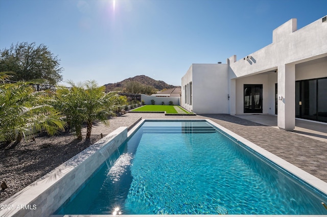 view of swimming pool with a patio and a mountain view