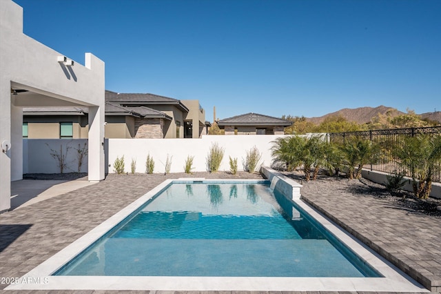 view of swimming pool featuring a mountain view and a patio