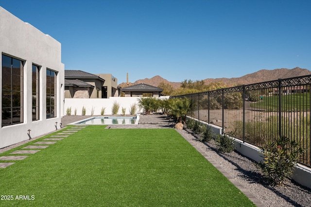 view of yard featuring a fenced in pool and a mountain view