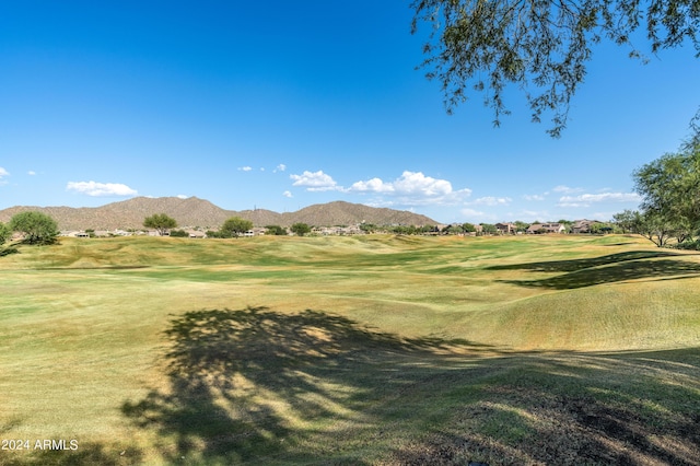 surrounding community with a yard and a mountain view