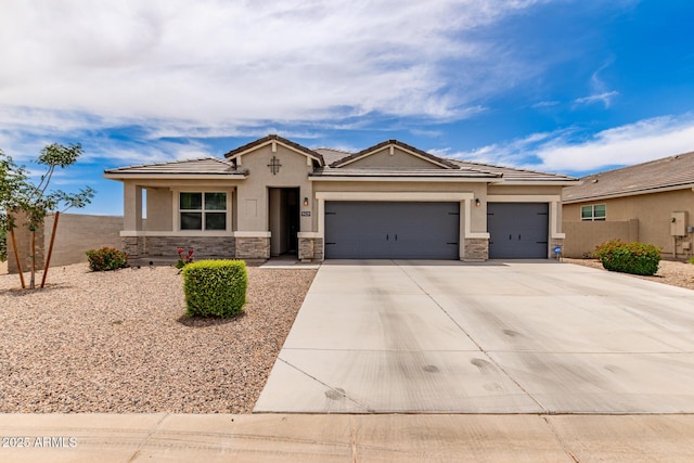 9429 E Grapefruit Dr, Florence, AZ 85132 - view of front of house featuring stone siding, a garage, driveway, stucco siding, and a tile roof