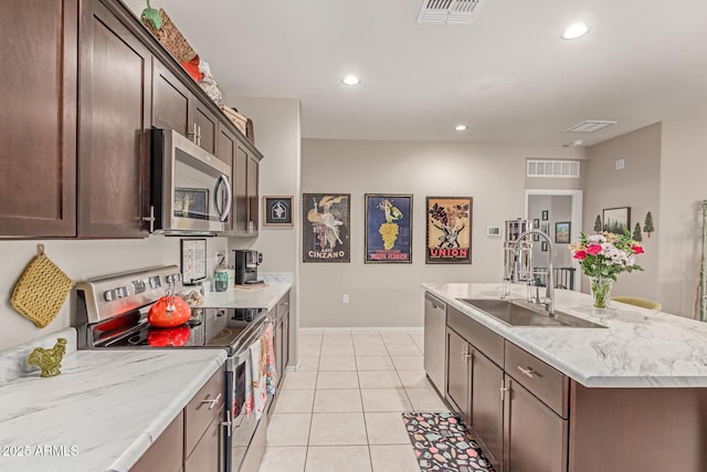 9429 E Grapefruit Dr, Florence, AZ 85132 - kitchen featuring stainless steel appliances, a sink, recessed lighting, a kitchen island with sink, and light tile patterned floors