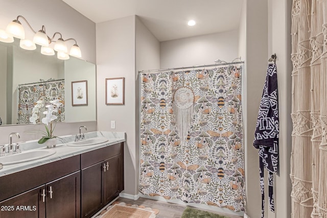 9429 E Grapefruit Dr, Florence, AZ 85132 - bathroom with double vanity, curtained shower, and wood finished floors