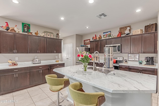 9429 E Grapefruit Dr, Florence, AZ 85132 - kitchen featuring appliances with stainless steel finishes, light tile patterned floors, a sink, dark brown cabinetry, and recessed lighting