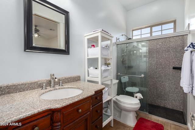 bathroom featuring walk in shower, hardwood / wood-style floors, vanity, and toilet