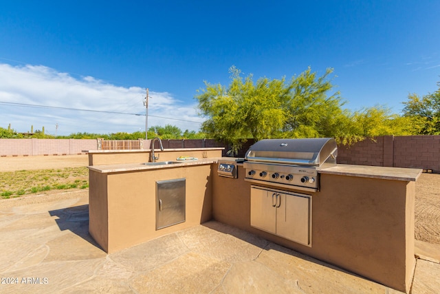 view of patio / terrace with area for grilling, sink, and a grill