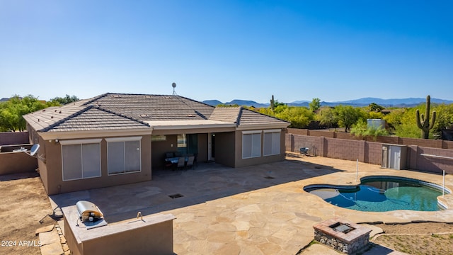 exterior space with a mountain view, a patio area, and a jacuzzi